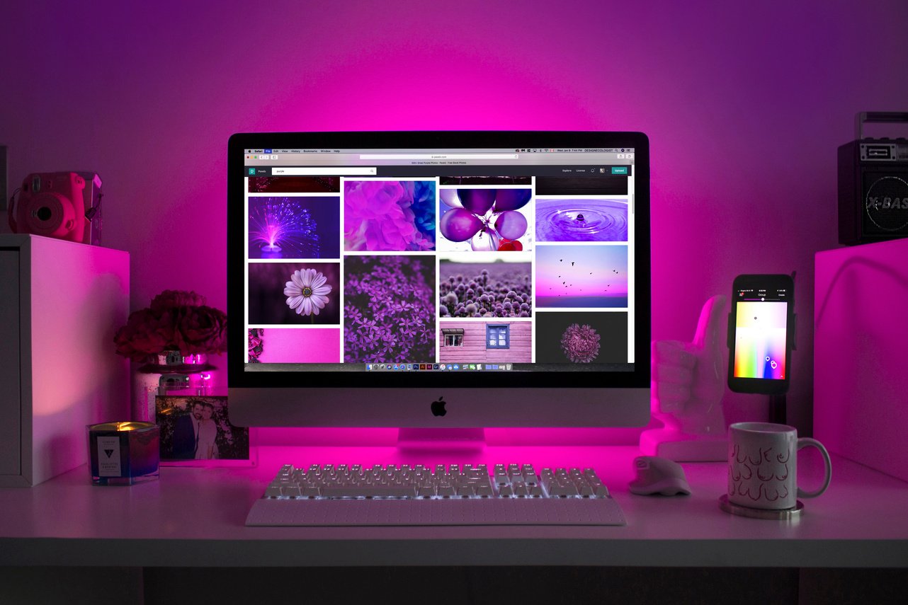 an image of a computer screen lit up with purple light showing website design by a graphic designer.